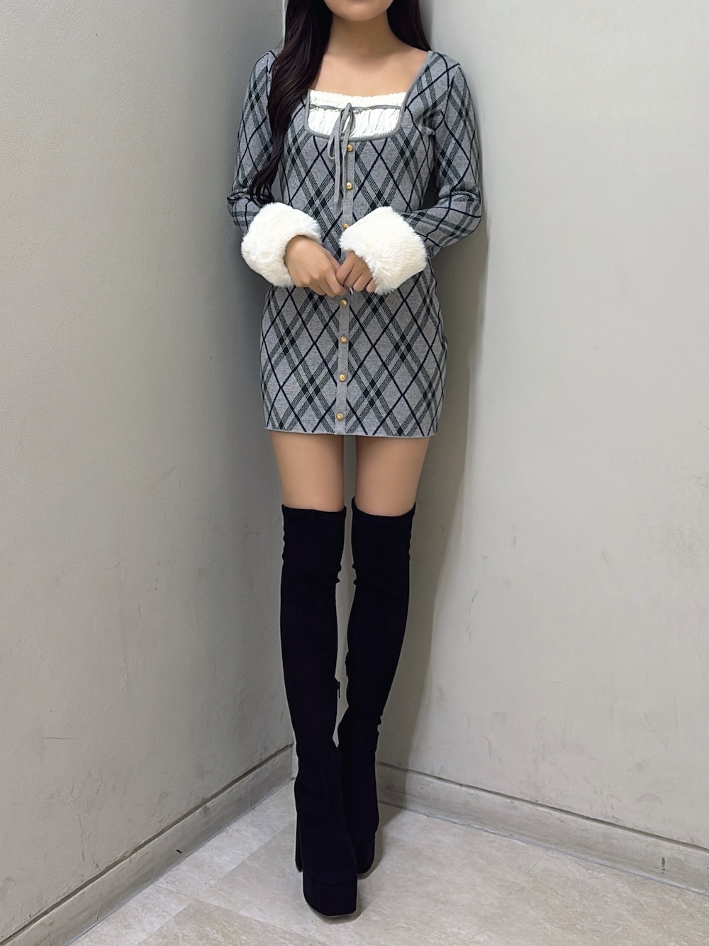 グレー系のワンピース、ブラック系のブーツを着用したレディースの秋コーディネートの1枚目の写真