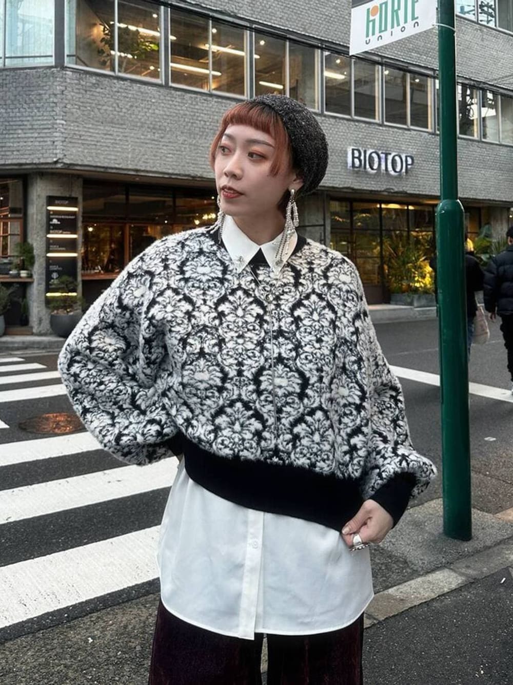 ブラック系のニット/セーター、レッド系のデニムパンツ、ホワイト系のシャツ/ブラウスを着用したレディースの秋コーディネートの1枚目の写真