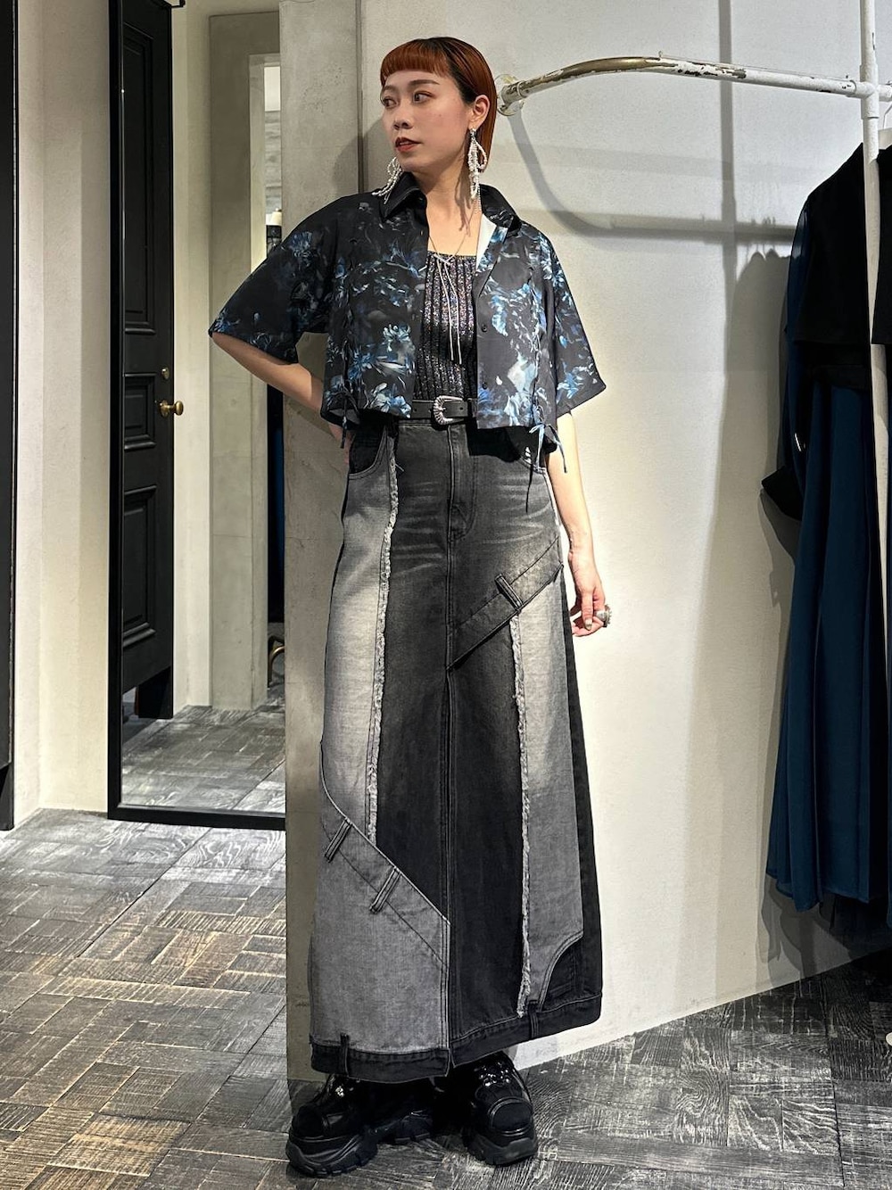 ブラック系のタンクトップ、ブラック系のサンダル、ブラック系のデニムスカートを着用したレディースの春コーディネートの1枚目の写真