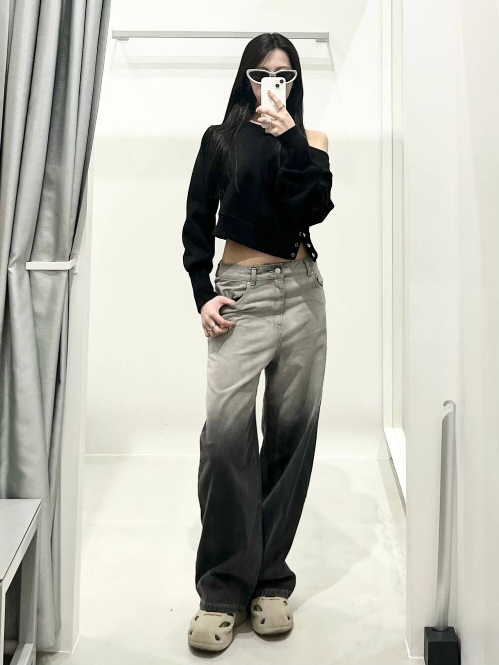 ブラック系のデニムパンツを着用したレディースの春コーディネートの1枚目の写真