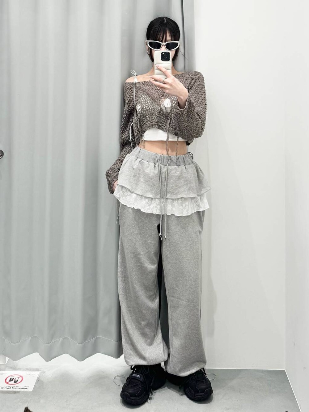 グレー系のニット/セーター、グレー系のスウェットパンツを着用したレディースの春コーディネートの1枚目の写真