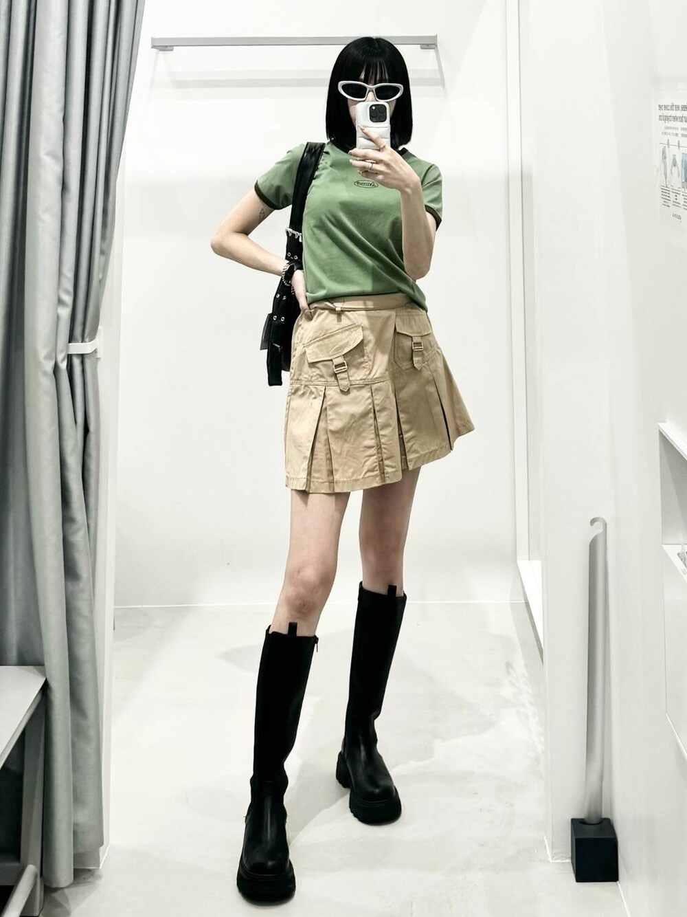 ベージュ系のスカート、グリーン系のTシャツ/カットソーを着用したレディースの春コーディネートの1枚目の写真