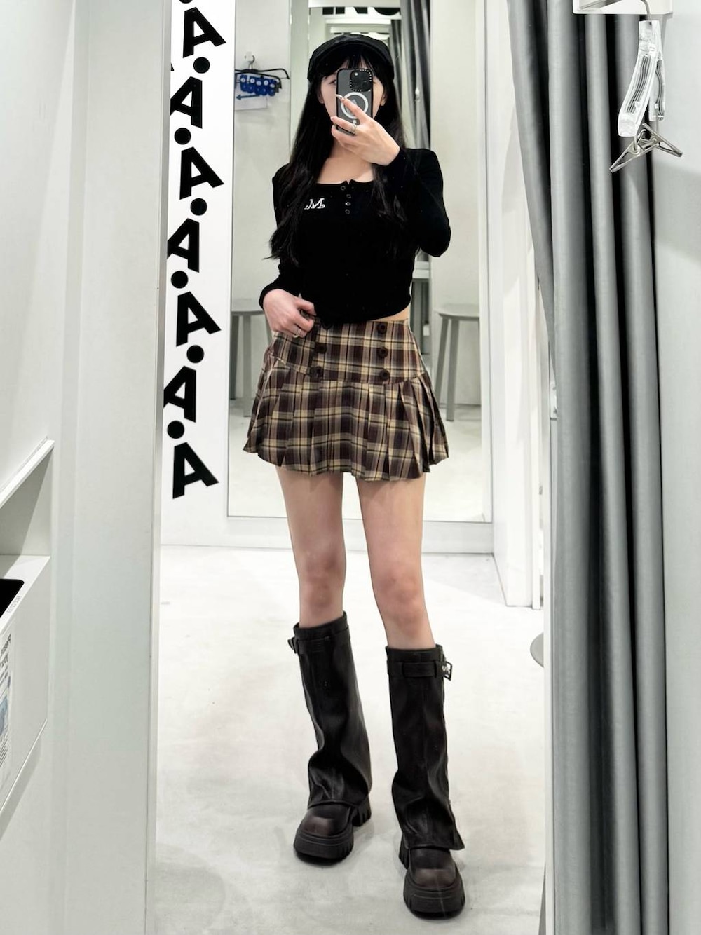 ベージュ系のスカート、ブラック系のTシャツ/カットソー、ブラック系のブーツを着用したレディースの秋コーディネートの1枚目の写真