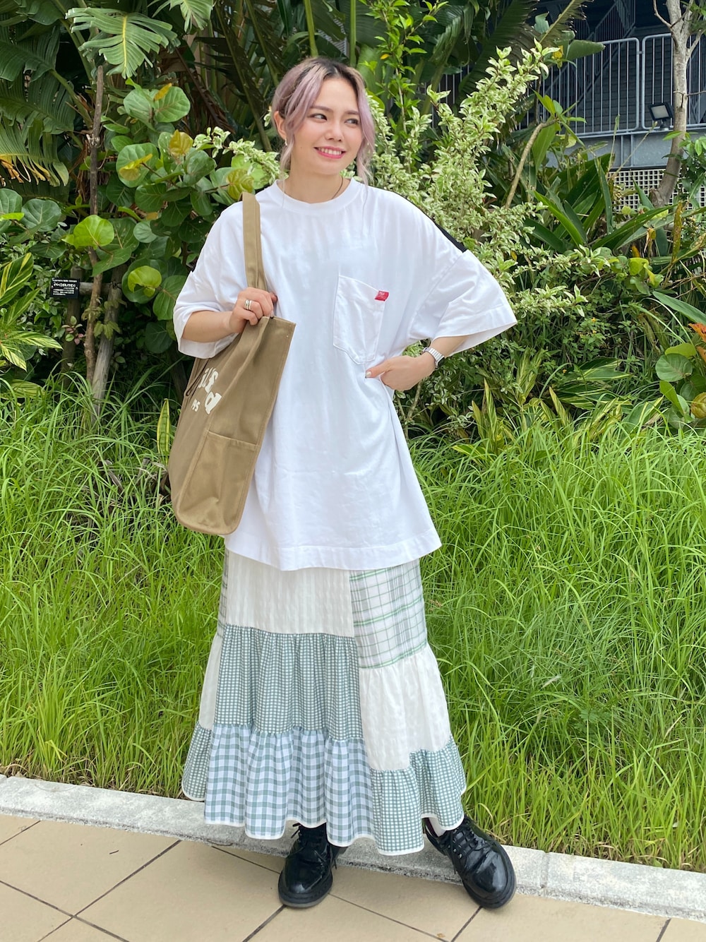 ベージュ系のトートバッグ、グリーン系のスカート、ホワイト系のTシャツ/カットソーを着用したレディースの夏コーディネートの1枚目の写真