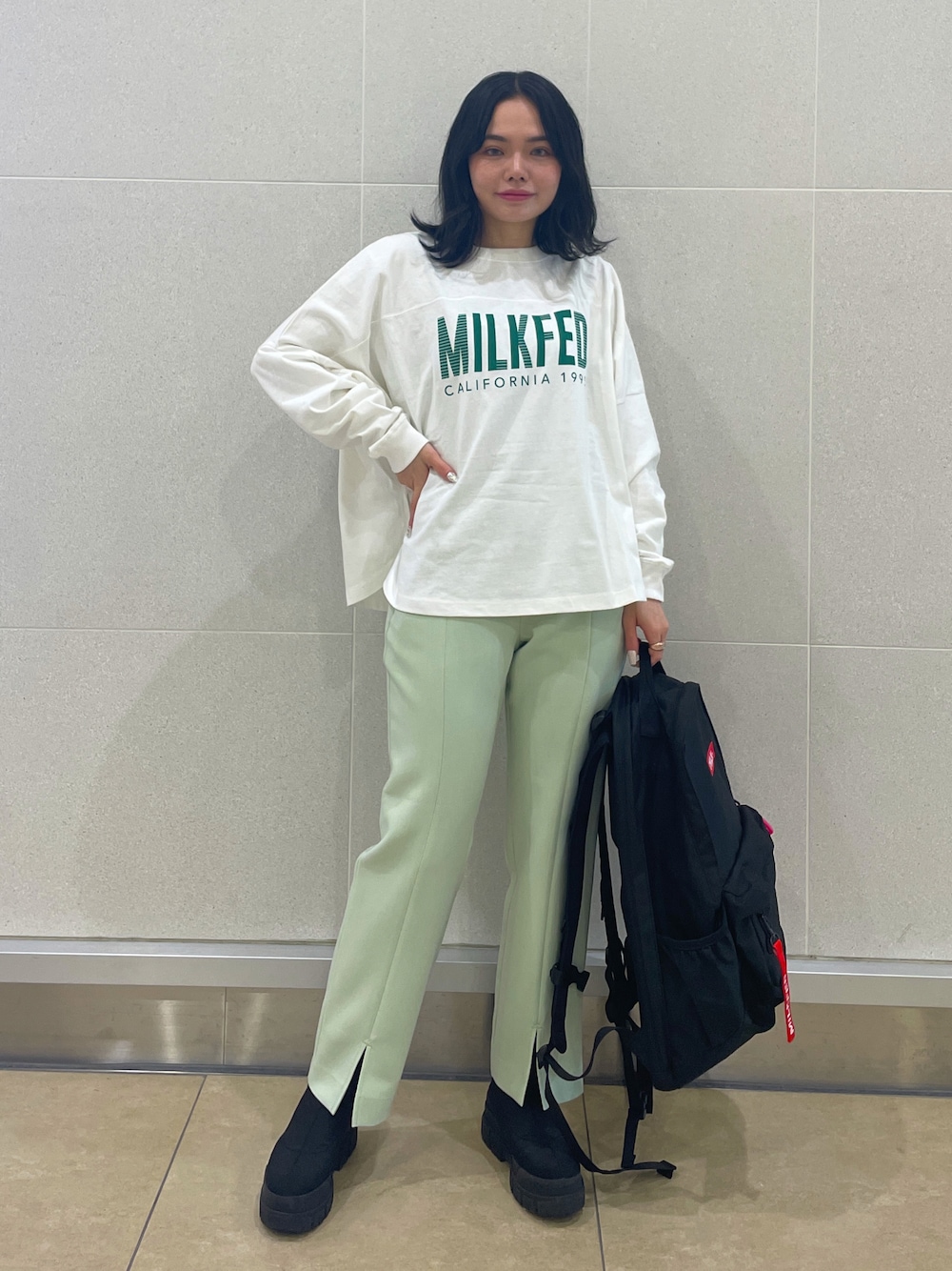 イエロー系のその他パンツ、レッド系のバックパック/リュック、ホワイト系のTシャツ/カットソーを着用したレディースの春コーディネートの1枚目の写真