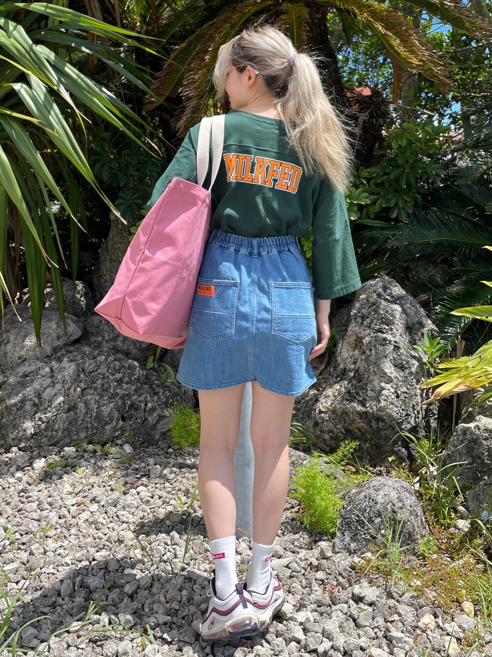 ブラック系のTシャツ/カットソー、ブルー系のスカート、ピンク系のトートバッグを着用したレディースの夏コーディネートの1枚目の写真