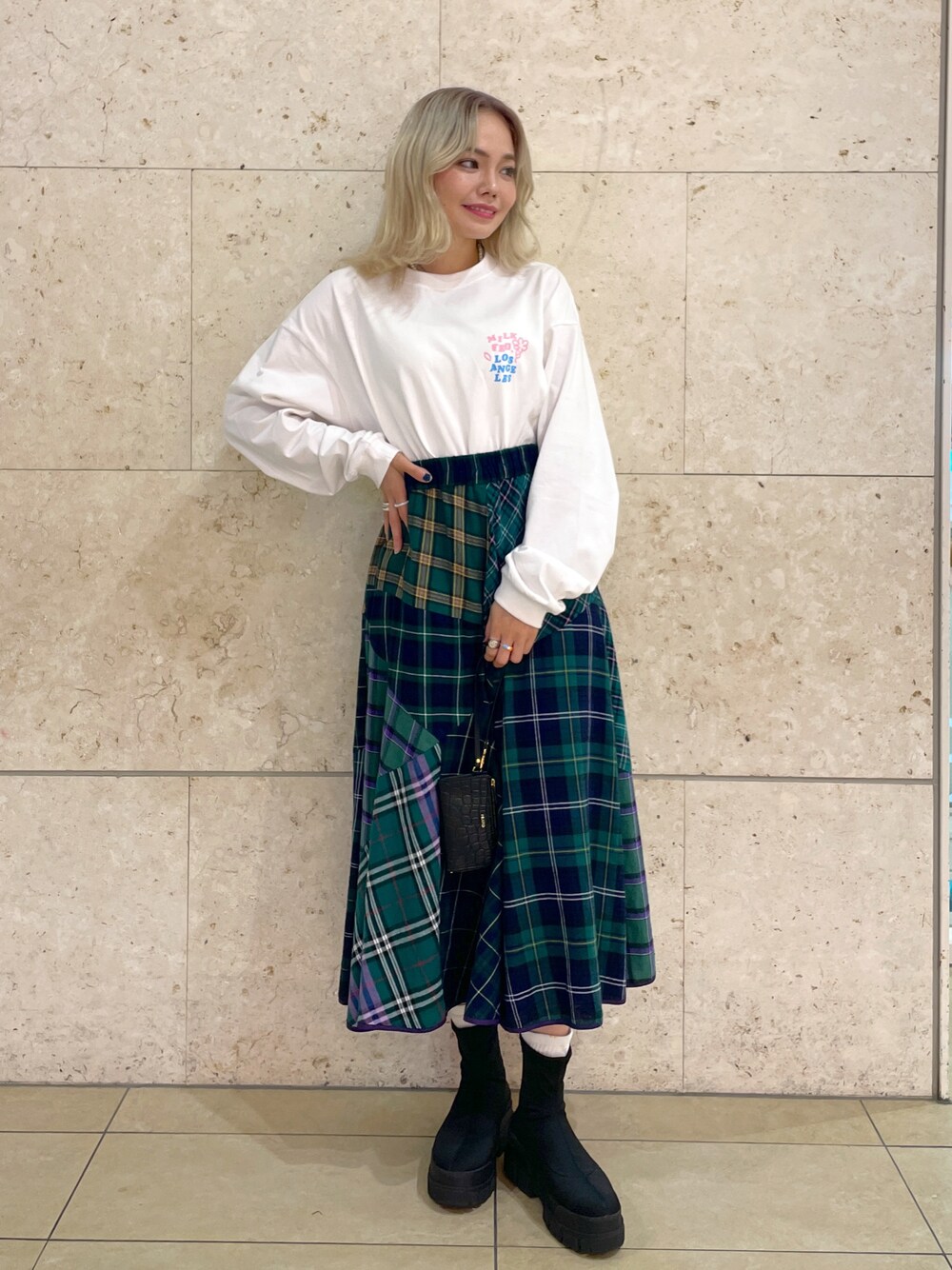 ホワイト系のTシャツ/カットソー、ブルー系のスカート、ブラック系のシューズを着用したレディースの秋コーディネートの1枚目の写真