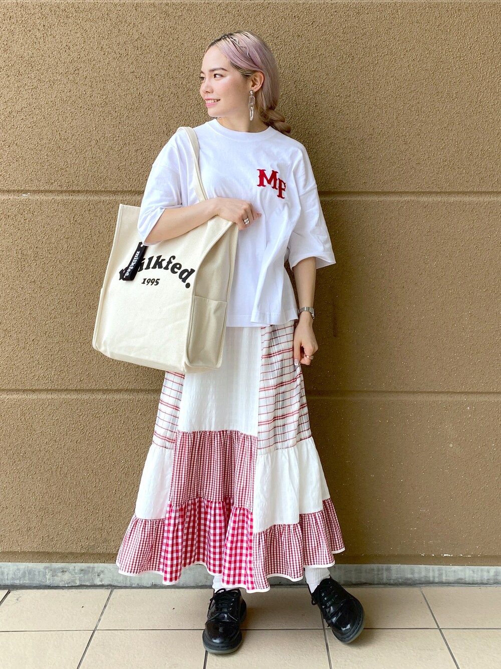 ホワイト系のTシャツ/カットソー、ホワイト系のトートバッグ、グリーン系のスカートを着用したレディースの夏コーディネートの1枚目の写真