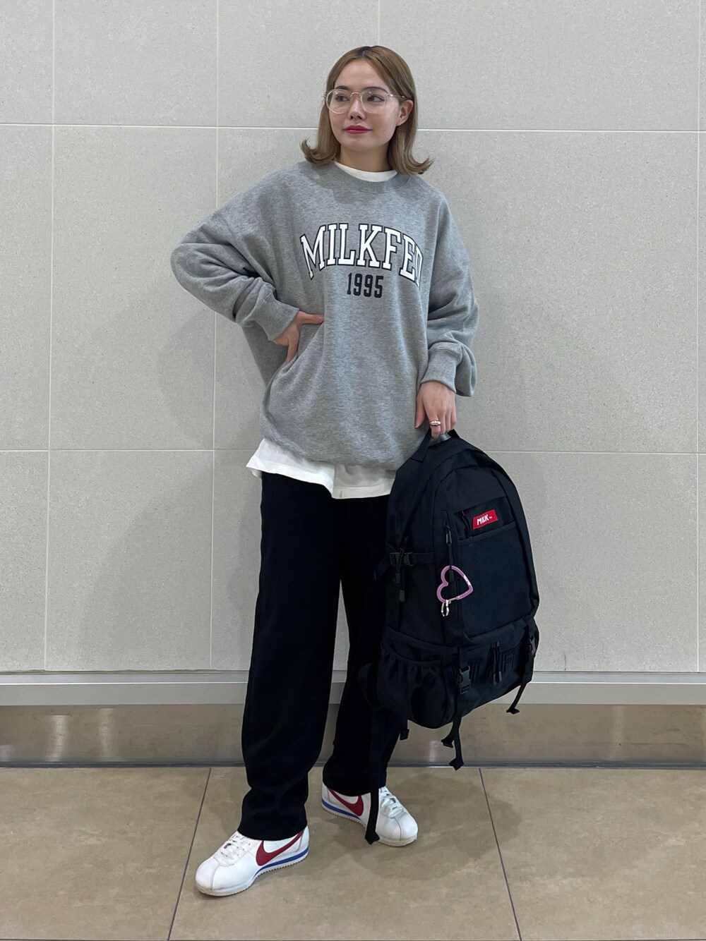 ブラック系のその他パンツ、グレー系のスウェット、レッド系のバックパック/リュックを着用したレディースの冬コーディネートの1枚目の写真