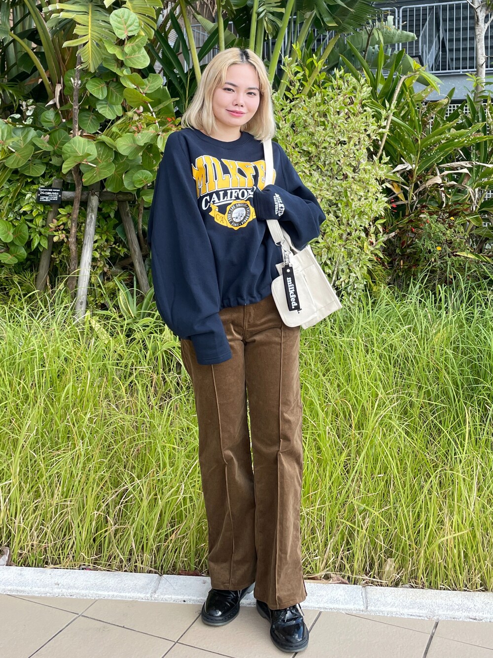 グレー系のその他パンツ、ブルー系のスウェット、ホワイト系のショルダーバッグを着用したレディースの冬コーディネートの1枚目の写真