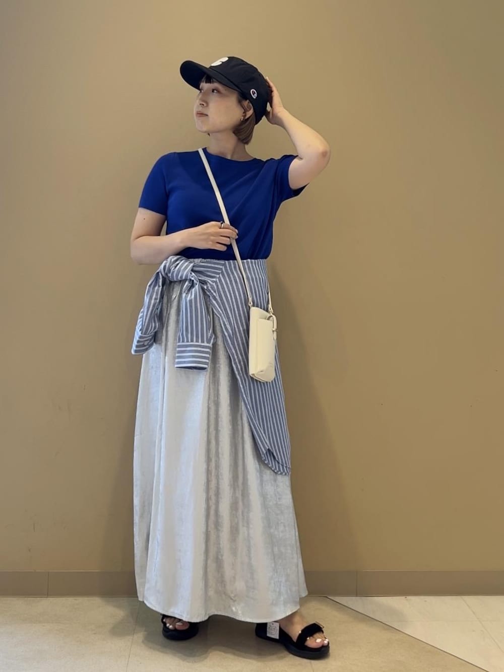 シルバー系のスカート、ブルー系のニット/セーター、ブラック系のサンダルを着用したレディースの夏コーディネートの1枚目の写真