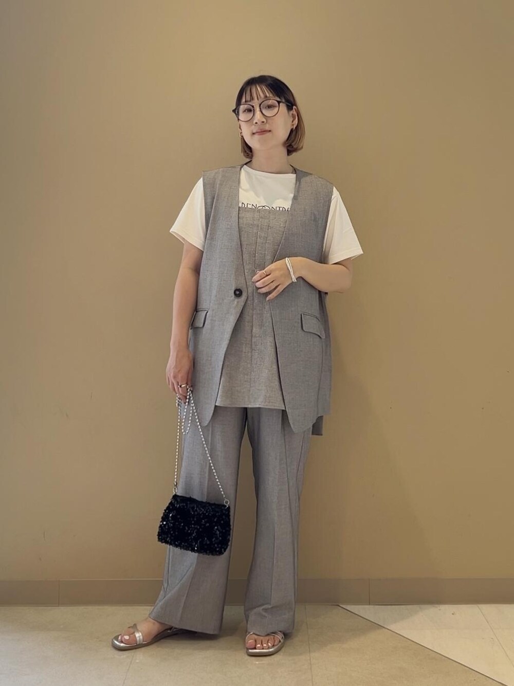 グレー系のキャミソール、ホワイト系のTシャツ/カットソー、グレー系のその他パンツを着用したレディースの春コーディネートの1枚目の写真