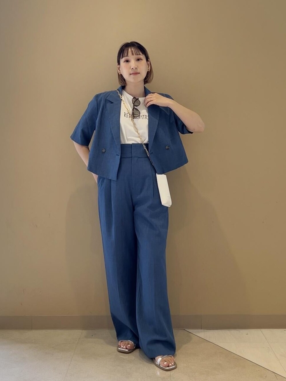 シルバー系のサンダル、ホワイト系のショルダーバッグ、ホワイト系のTシャツ/カットソーを着用したレディースの春コーディネートの1枚目の写真