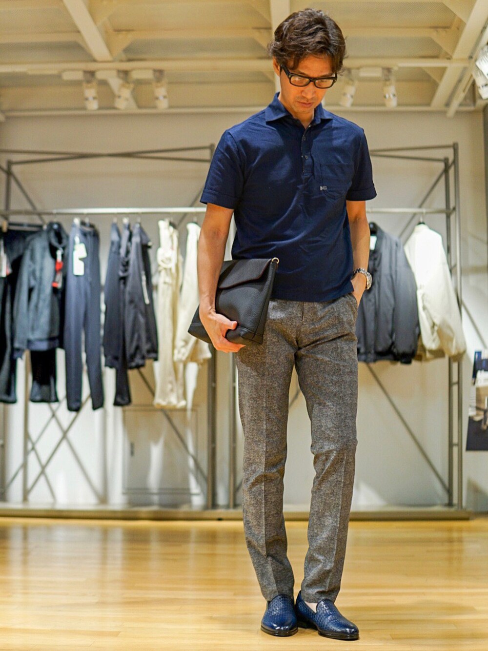 ブルー系のポロシャツ、グレー系のスラックス、イエロー系のスリッポンを着用したメンズの春コーディネートの1枚目の写真