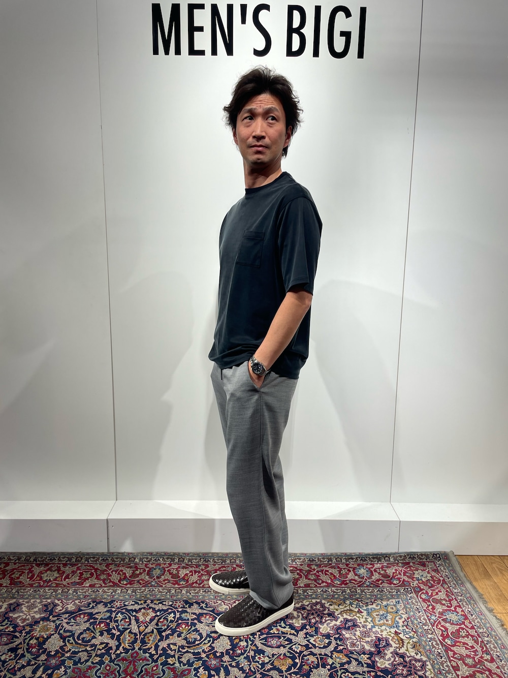 ブラック系のTシャツ/カットソー、グレー系のその他パンツ、ブラウン系のスリッポンを着用したメンズの春コーディネートの1枚目の写真