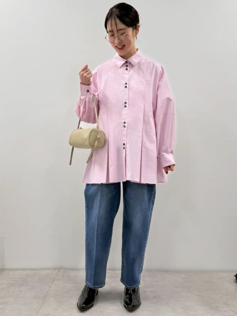 ブラック系のローファー、ピンク系のシャツ/ブラウス、ベージュ系のボストンバッグを着用したレディースの冬コーディネートの1枚目の写真