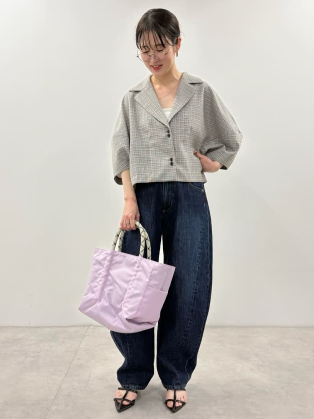 ブルー系のデニムパンツ、ブラック系のシャツ/ブラウス、ブラウン系のトートバッグを着用したレディースの春コーディネートの1枚目の写真