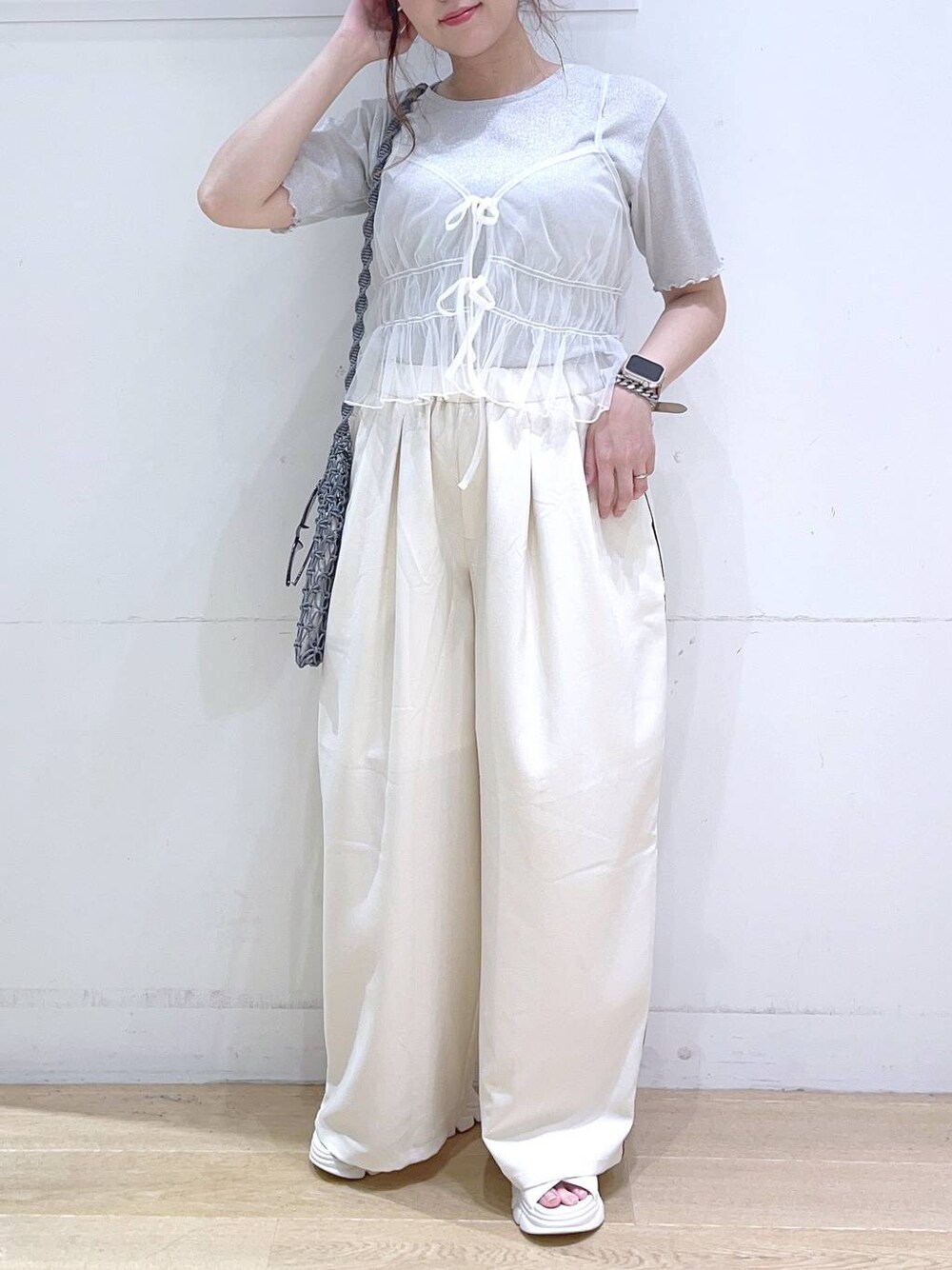 ホワイト系のサンダル、ホワイト系のキャミソール、グレー系のショルダーバッグを着用したレディースの夏コーディネートの1枚目の写真