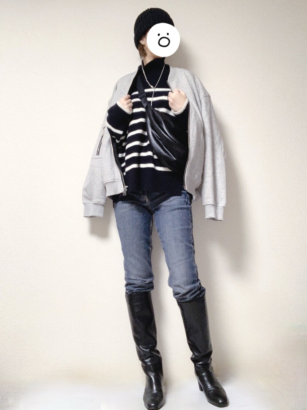 ブルー系のデニムパンツ、ブラック系のブーツ、ブラック系のショルダーバッグを着用したレディースの冬コーディネートの1枚目の写真