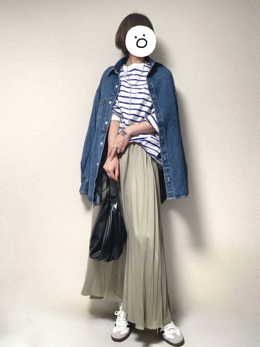 ホワイト系のスニーカー、グレー系のスカート、ブラック系のショルダーバッグを着用したレディースの春コーディネートの1枚目の写真