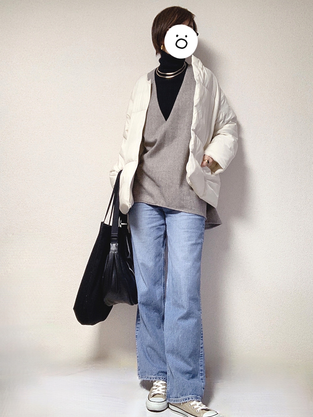 ベージュ系のスニーカー、ブルー系のデニムパンツ、ブラック系のショルダーバッグを着用したレディースの冬コーディネートの1枚目の写真