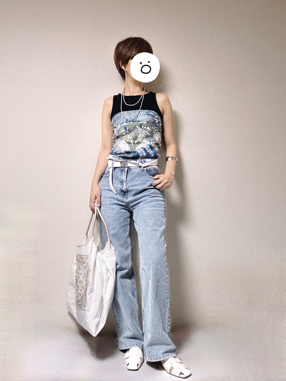 ブルー系のデニムパンツ、ブラック系のタンクトップ、ホワイト系のサンダルを着用したレディースの夏コーディネートの1枚目の写真