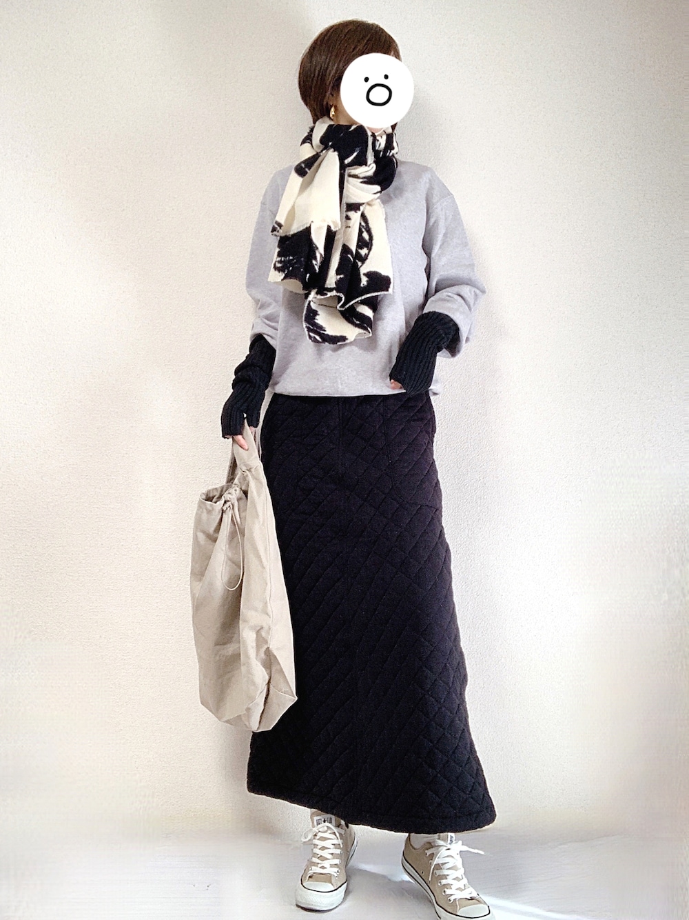 ベージュ系のスニーカー、グレー系のスウェット、ブラック系のスカートを着用したレディースの冬コーディネートの1枚目の写真