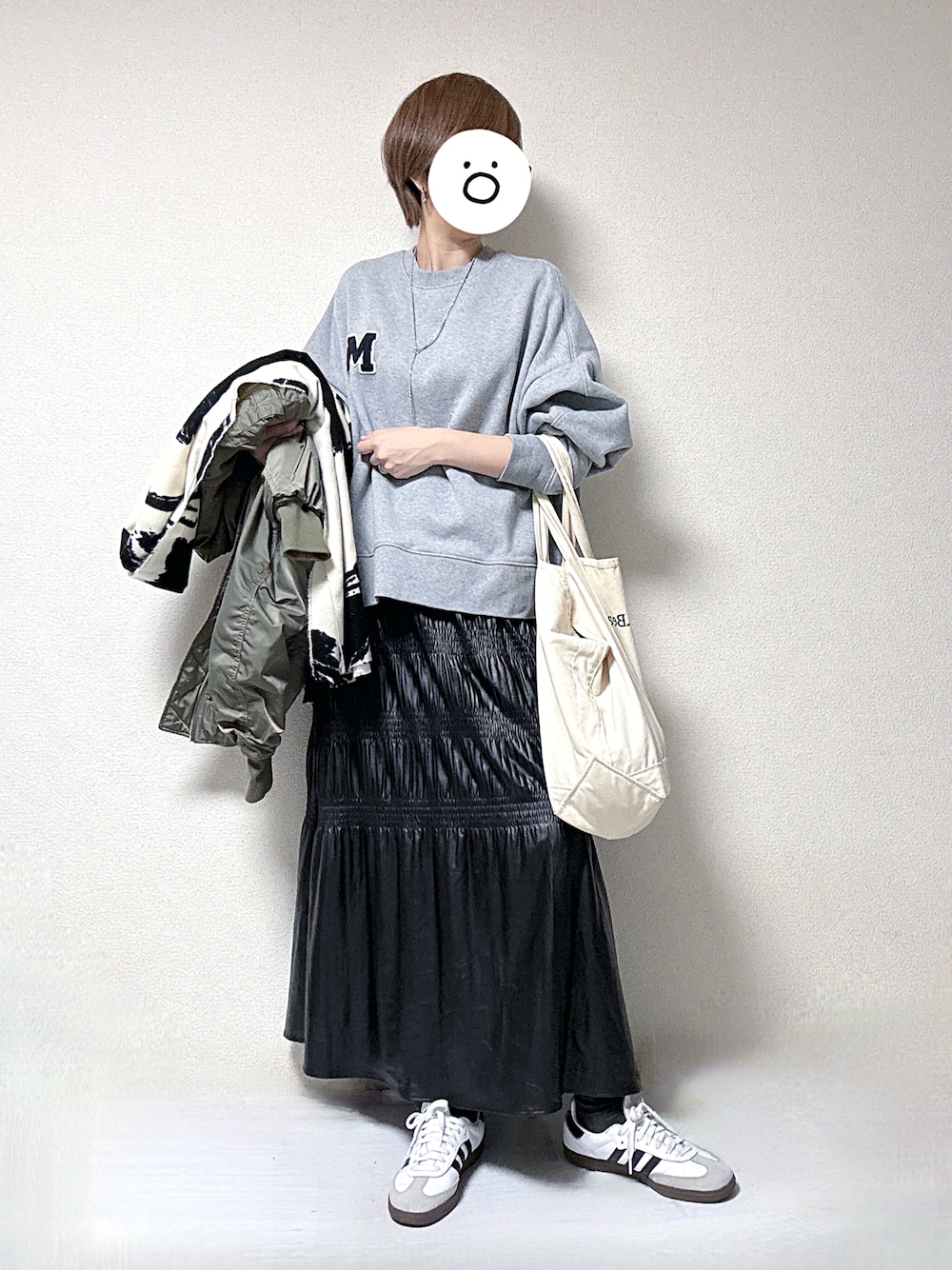 グレー系のスウェット、ブラック系のスカート、ブラック系のMA-1を着用したレディースの冬コーディネートの1枚目の写真