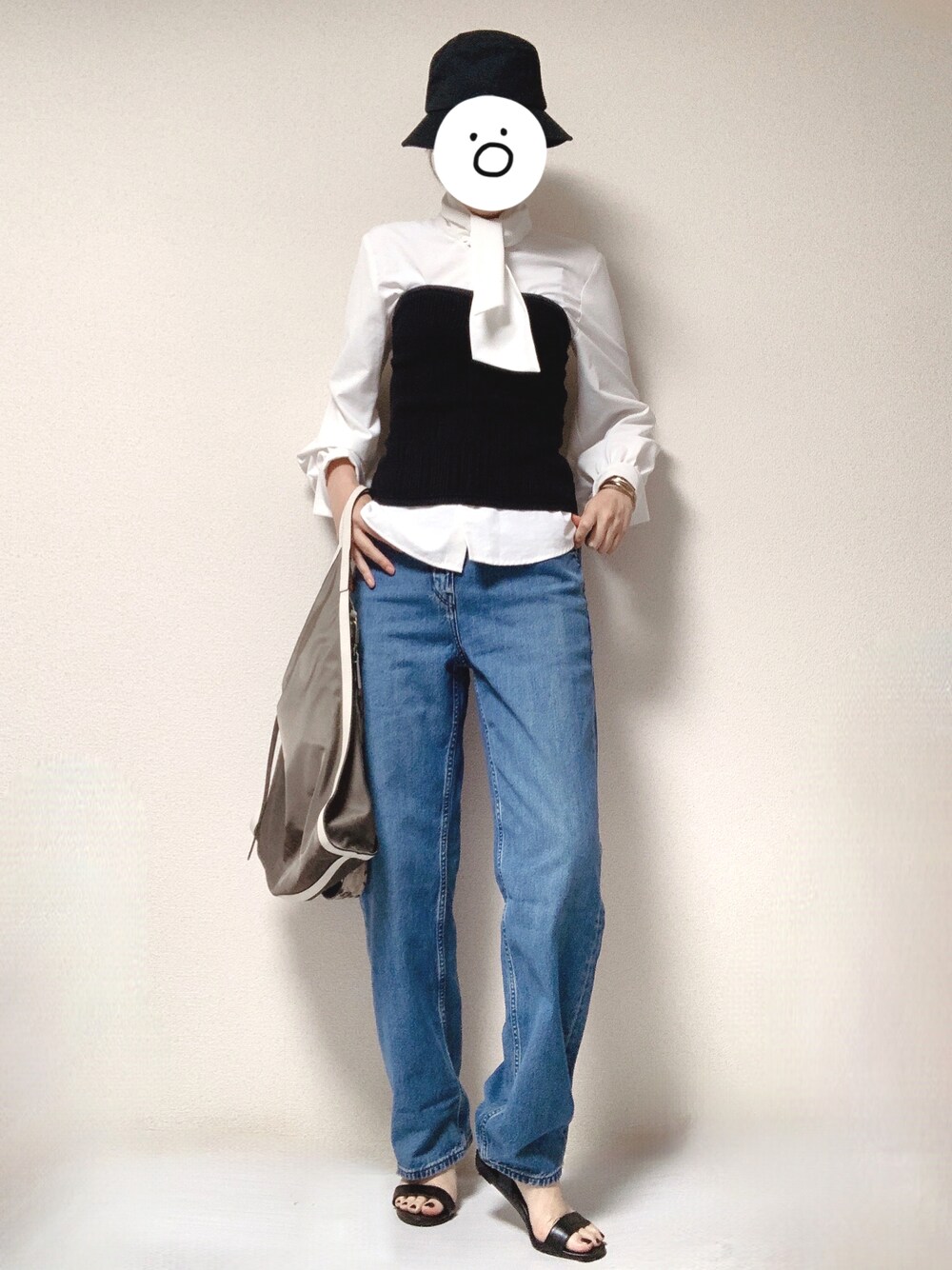 ブルー系のデニムパンツ、ブラック系のサンダル、グリーン系のショルダーバッグを着用したレディースの秋コーディネートの1枚目の写真