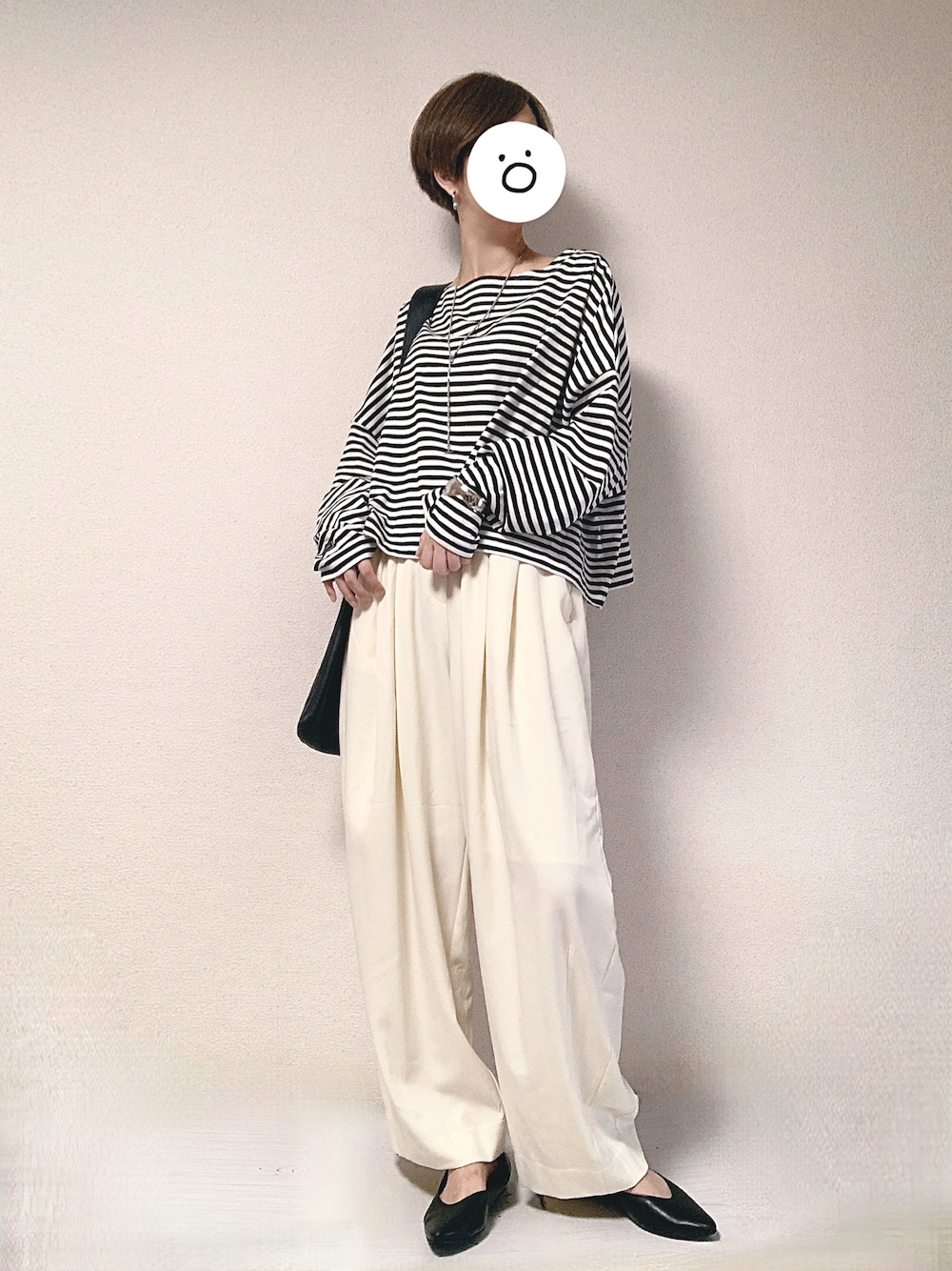 ホワイト系のスラックス、ホワイト系のTシャツ/カットソー、ブラック系のトートバッグを着用したレディースの秋コーディネートの1枚目の写真