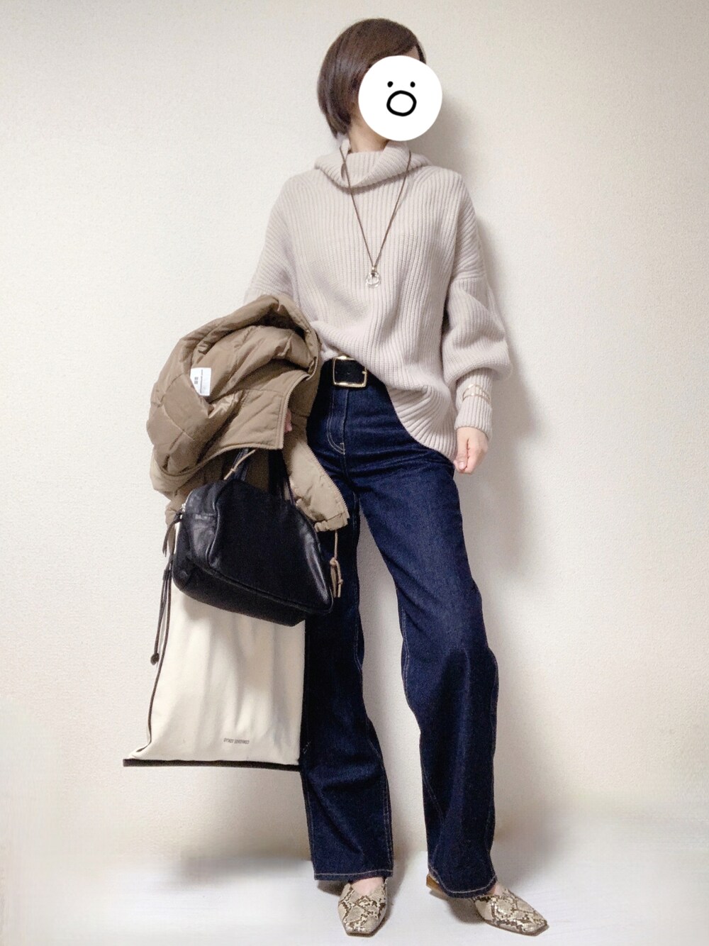 ベージュ系のパンプス、ブルー系のデニムパンツ、ブラック系のトートバッグを着用したレディースの冬コーディネートの1枚目の写真