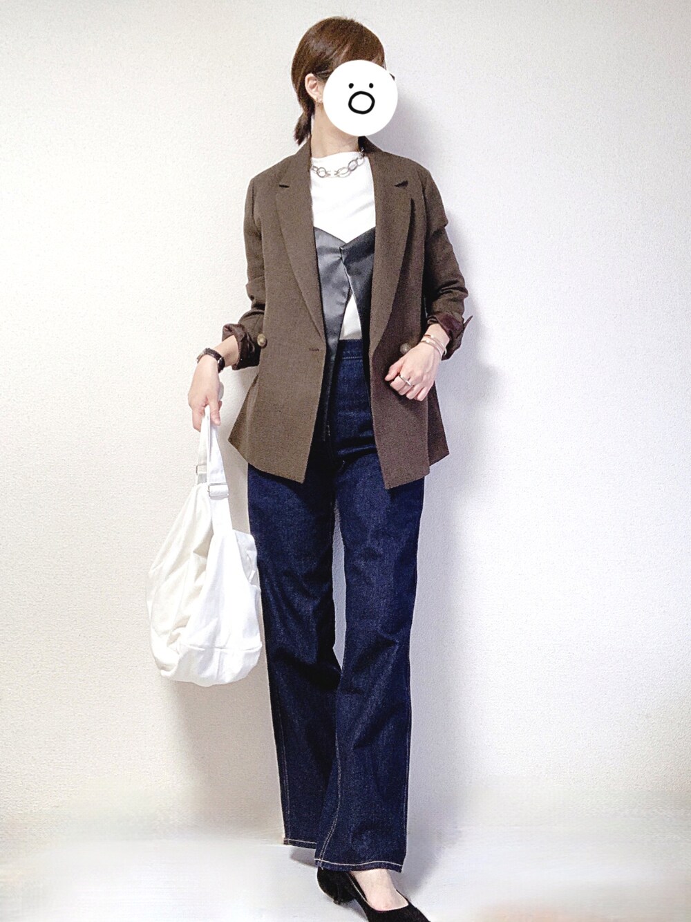 ホワイト系のショルダーバッグ、ブルー系のデニムパンツ、ブラック系のパンプスを着用したレディースの秋コーディネートの1枚目の写真