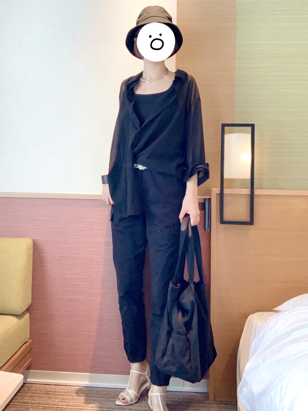 ホワイト系のサンダル、ブラック系のカーゴパンツ、ブラック系のタンクトップを着用したレディースの夏コーディネートの1枚目の写真