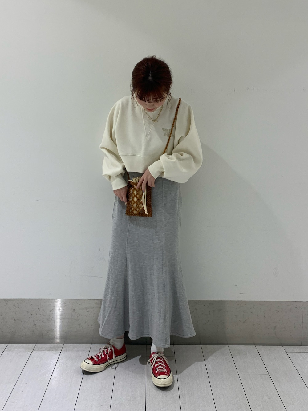 ホワイト系のスウェット、グレー系のスカート、ブラウン系のショルダーバッグを着用したレディースの冬コーディネートの1枚目の写真