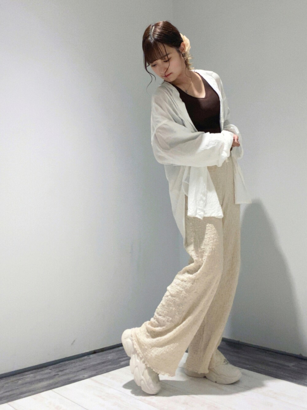 ホワイト系のシャツ/ブラウス、ブラウン系のタンクトップ、ベージュ系のパンツを着用したレディースの夏コーディネートの1枚目の写真