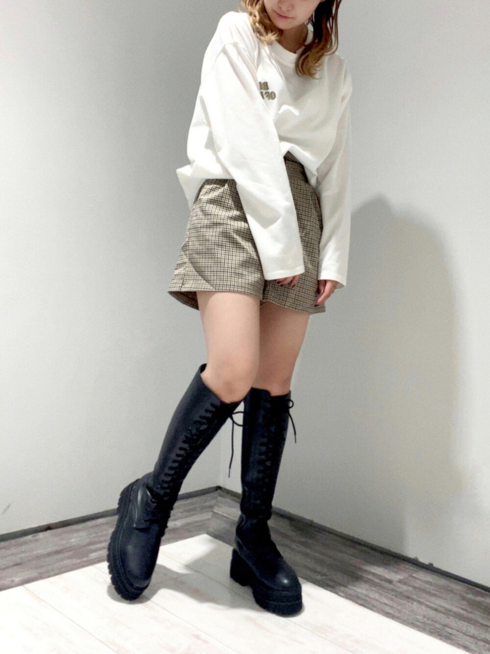 ブラック系のブーツ、ベージュ系のその他パンツ、ホワイト系のトップスを着用したレディースの秋コーディネートの1枚目の写真