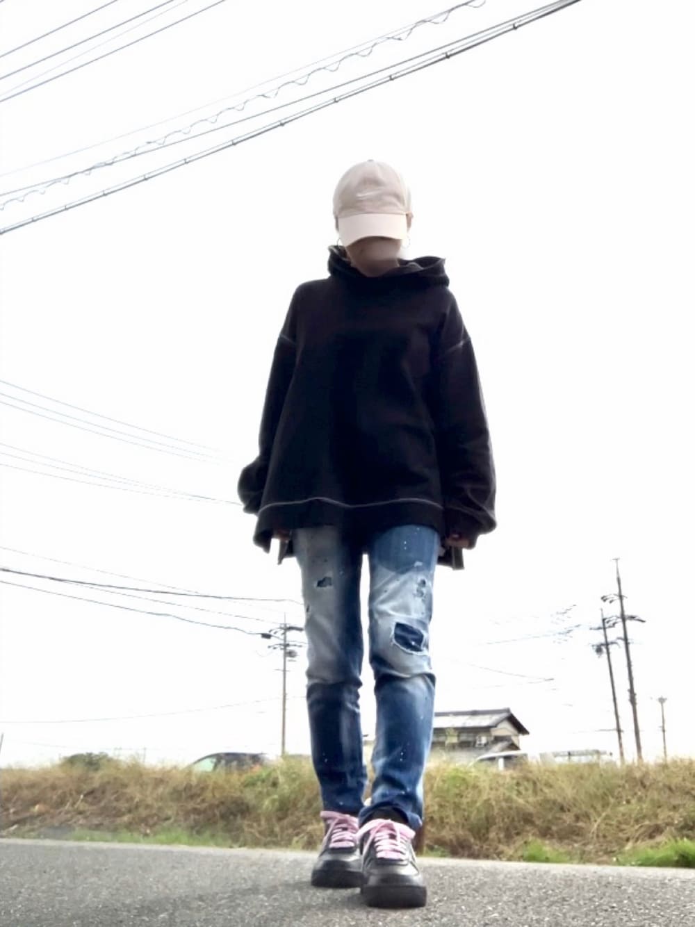 ブラック系のパーカー、ブルー系のデニムパンツ、ブラック系のスニーカーを着用したレディースの秋コーディネートの1枚目の写真