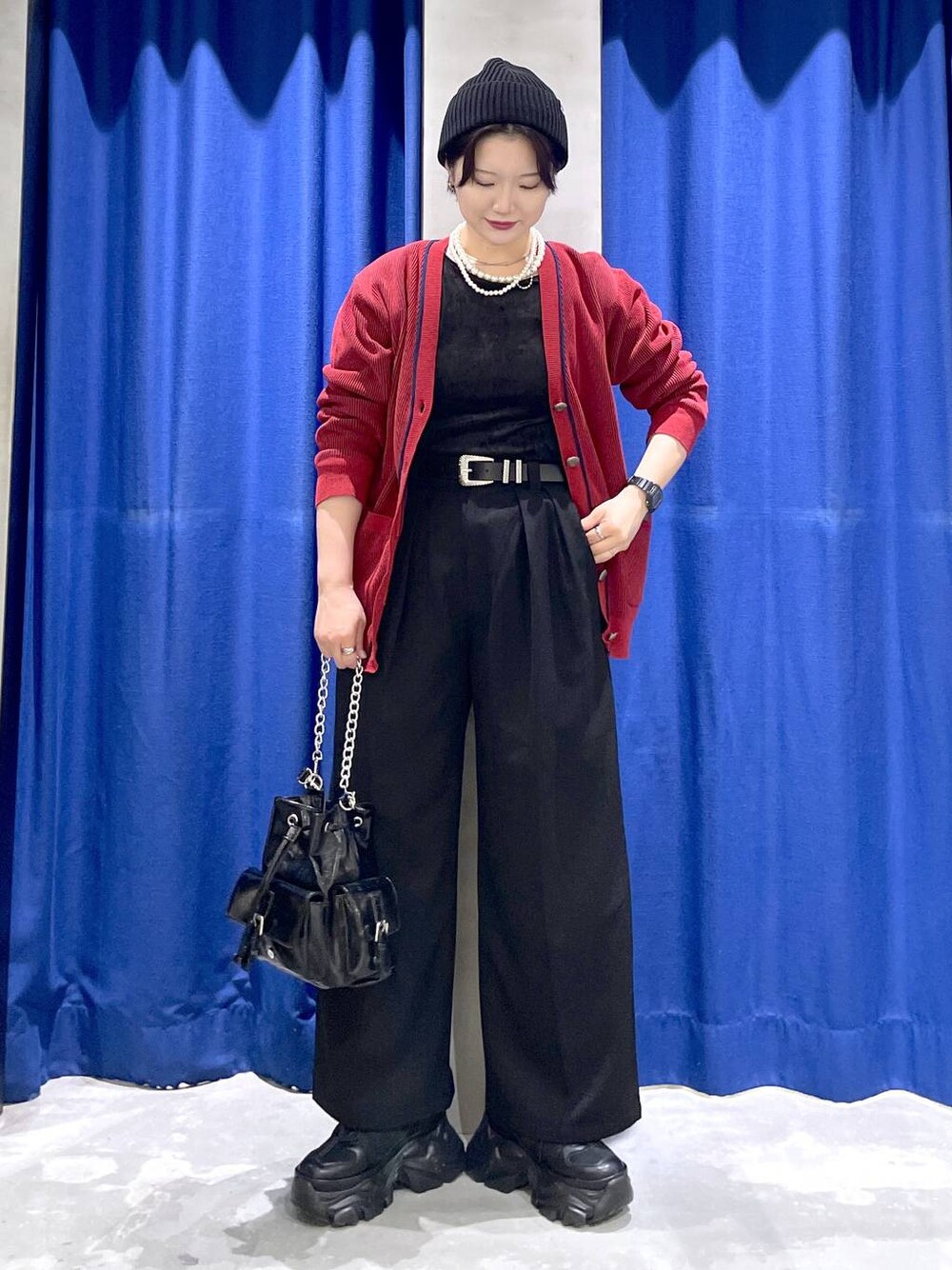 ブラック系のスニーカー、ブラック系のショルダーバッグ、レッド系のカーディガン/ボレロを着用したレディースの秋コーディネートの1枚目の写真