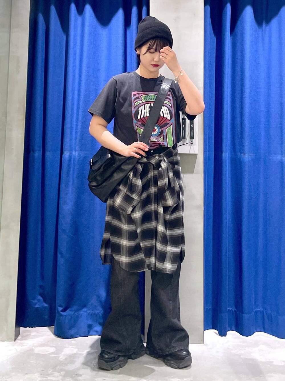 ブラック系のスニーカー、ブラック系のデニムパンツ、ブラック系のショルダーバッグを着用したレディースの秋コーディネートの1枚目の写真