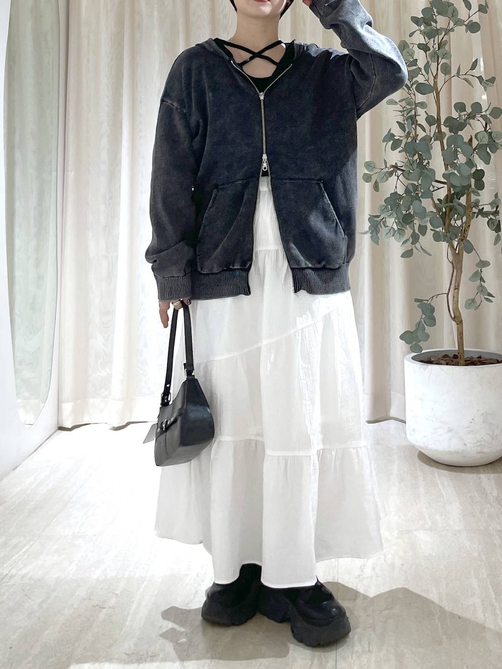 ブラック系のブーツ、ブラック系のハンドバッグ、ブラック系のニット/セーターを着用したレディースの冬コーディネートの1枚目の写真