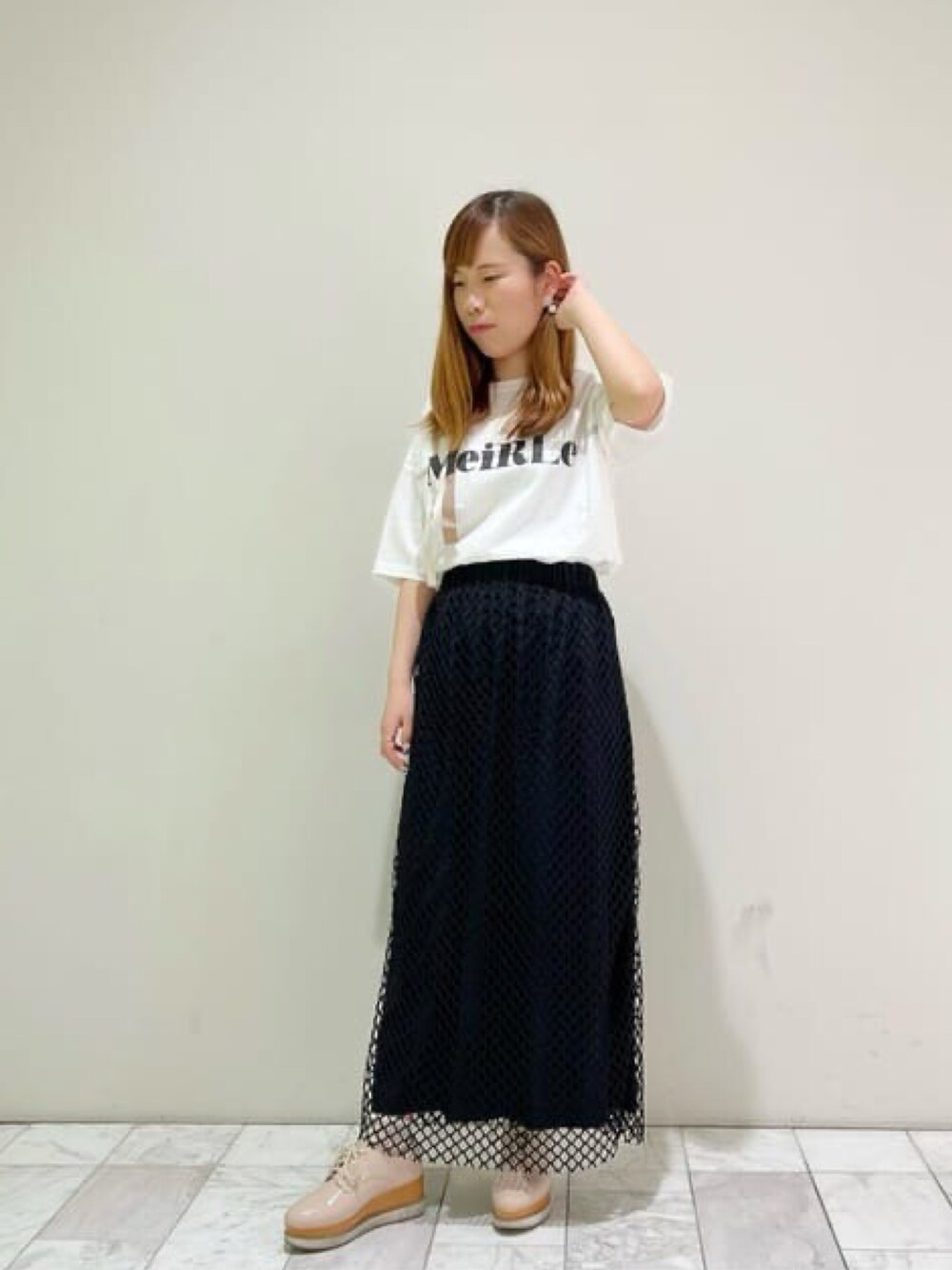 ホワイト系のTシャツ/カットソー、ブラック系のスカートを着用したレディースの春コーディネートの1枚目の写真