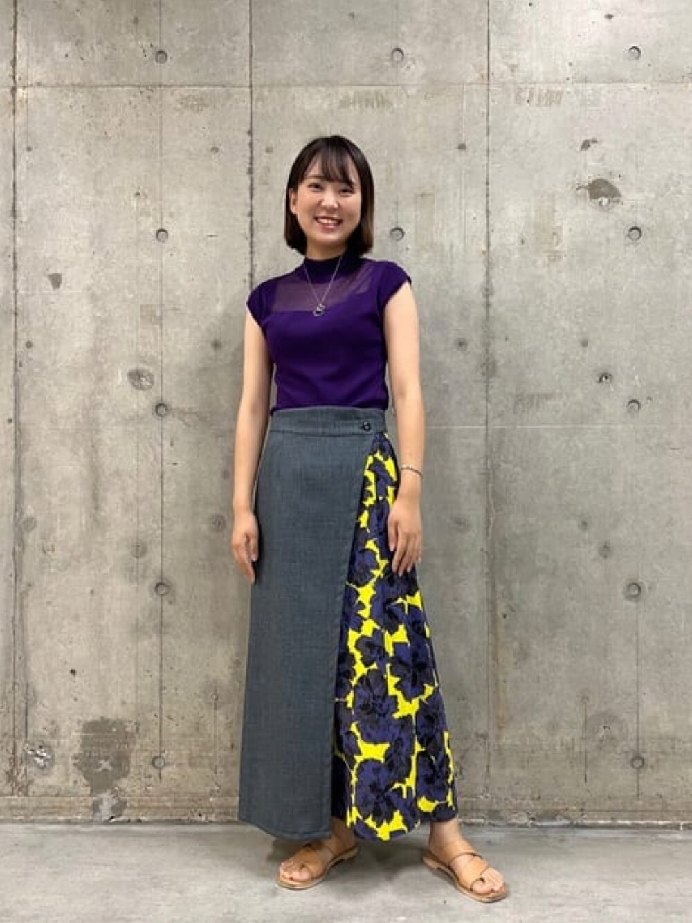 パープル系のニット/セーター、ブルー系のスカートを着用したレディースの夏コーディネートの1枚目の写真