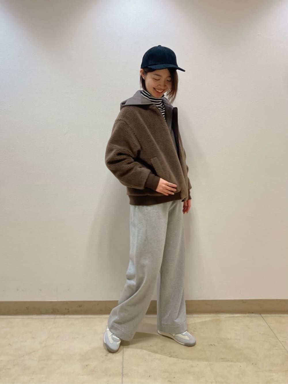 ブラウン系のブルゾン、グレー系のその他パンツ、ブラック系のキャップを着用したレディースの冬コーディネートの1枚目の写真