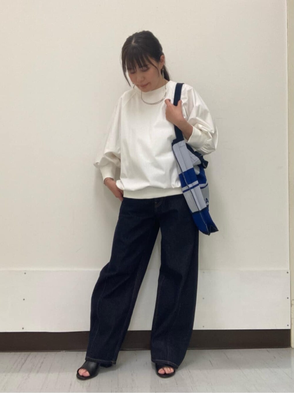 ホワイト系のTシャツ/カットソー、ブラック系のサンダル、ブルー系のデニムパンツを着用したレディースの夏コーディネートの1枚目の写真