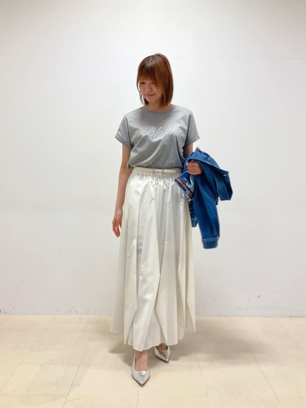 シルバー系のパンプス、グレー系のTシャツ/カットソーを着用したレディースの春コーディネートの1枚目の写真