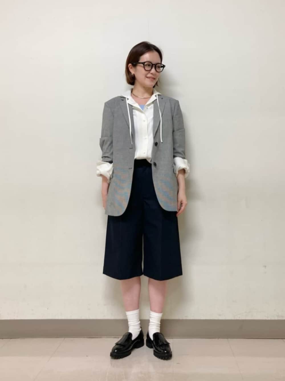 ホワイト系のシャツ/ブラウス、ブラック系のテーラードジャケット、ブルー系のその他パンツを着用したレディースの春コーディネートの1枚目の写真