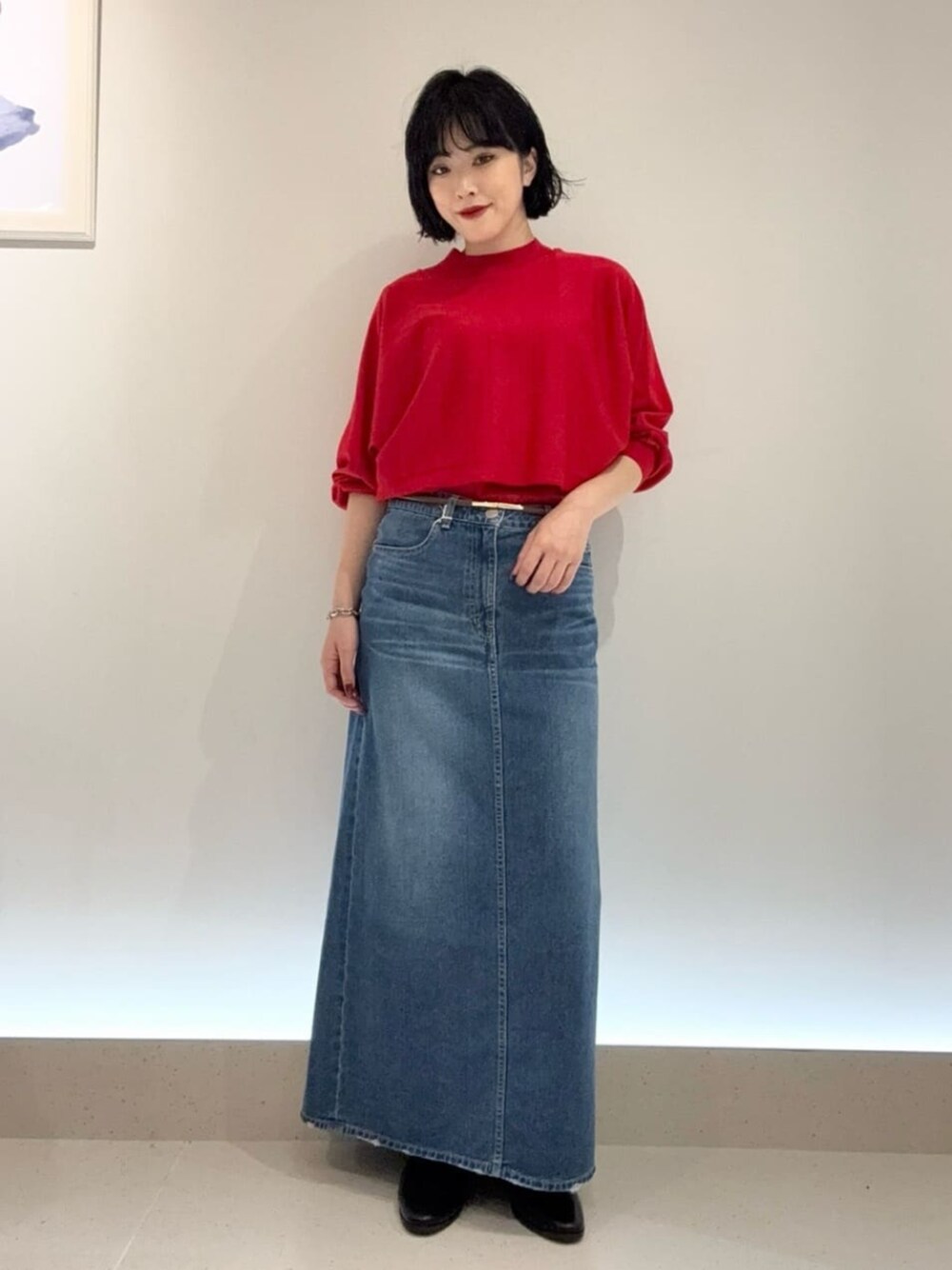 ブルー系のスカート、レッド系のアンサンブルを着用したレディースの秋コーディネートの1枚目の写真