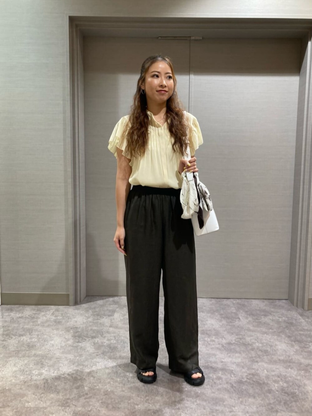 ホワイト系のショルダーバッグ、イエロー系のシャツ/ブラウス、ブラウン系のその他パンツを着用したレディースの夏コーディネートの1枚目の写真