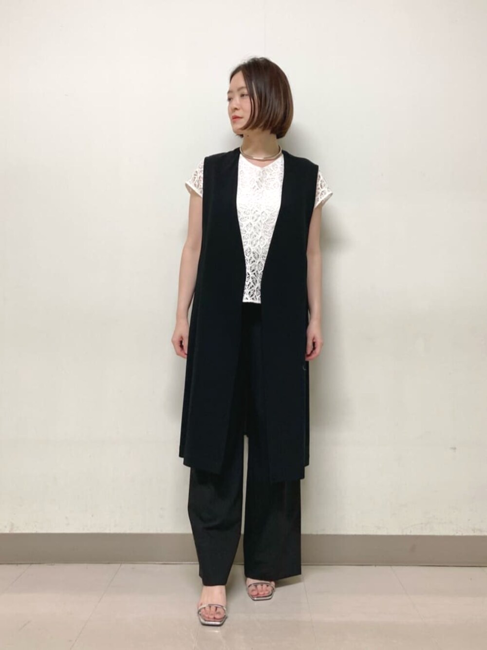 ブラック系のベスト、ホワイト系のシャツ/ブラウス、ブラック系のその他パンツを着用したレディースの春コーディネートの1枚目の写真