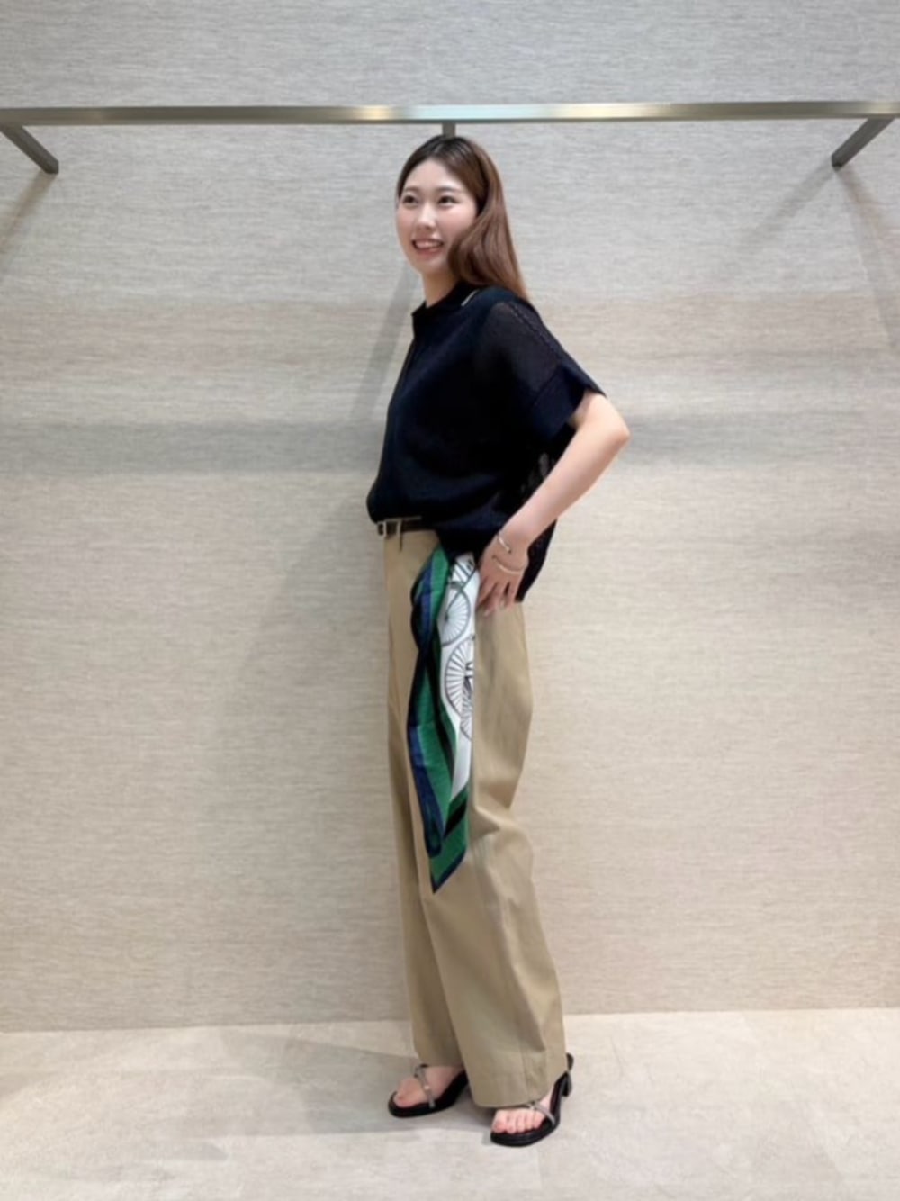 ブルー系のニット/セーター、グリーン系のチノパンツ、グリーン系のストール/ショールを着用したレディースの春コーディネートの1枚目の写真